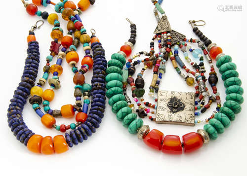 A collection of North African and Middle Eastern coloured bead necklaces, including a white metal