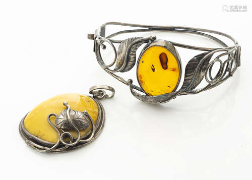 A contemporary Baltic amber bangle, the oval cabochon in pierced white metal leaf setting marked