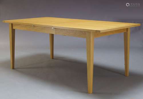 An oak extending dining table, of recent manufacture, the rectangular top with two additional