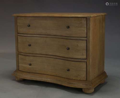 Feather and Black, a limed oak serpentine chest of drawers, of recent manufacture, with three