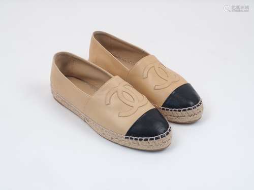 A pair of Chanel lambskin espadrilles, designed in beige and black, with distinctive Chanel logo,