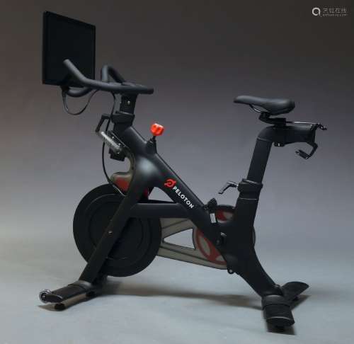 A Peloton indoor exercise bike, together with Peloton weights, shoes, and other accessoriesPlease