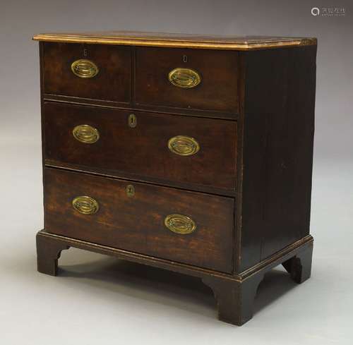 A George III mahogany chest, with two short over two long graduated drawers, raised on shaped