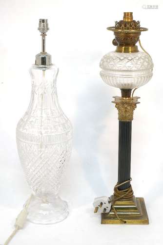 A late Victorian oil lamp, with brass fitting and glass reservoir, on fluted column with