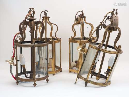 A pair of brass curving hexagonal form hall lanterns, 20th century, with scrolling form tops to