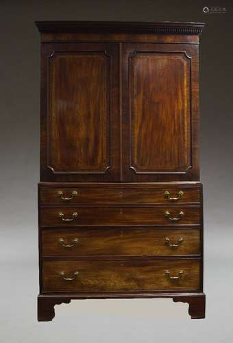 A George III mahogany linen press secretaire, the dentil moulded cornice above two panelled and