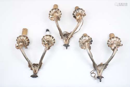 A set of three Edwardian twin branch electrical wall sconces, designed with foliate scroll motifs,