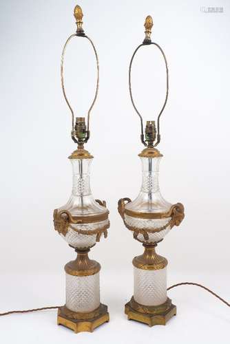 A pair of early 20th century glass and brass table lamps, with ram's head and swag fittings to the