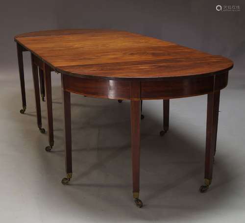 A George III and later mahogany extending dining table, with two D-ends flanking drop leaf central