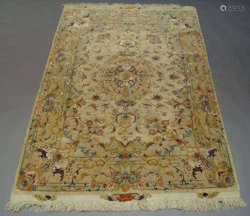 A part silk Tabriz rug, late 20th Century, having central foliate medallion in ivory field, with