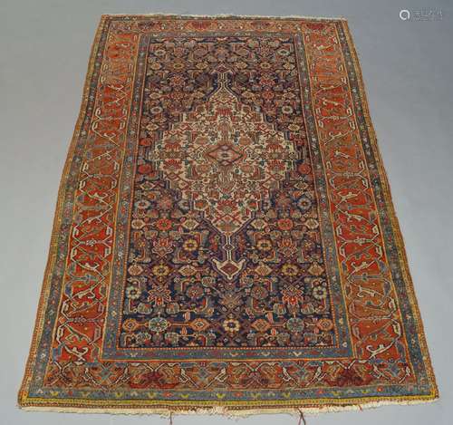 A Hamadan rug, with ivory lozenge medallion in indigo field, the brick red main border with stylised