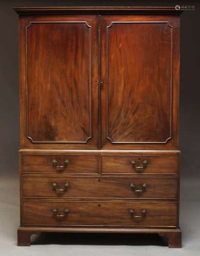 A mahogany linen press, 19th Century, with dentil moulded cornice above two panelled doors enclosing