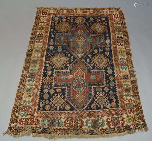 A Kazak rug, with two cruciform medallions in indigo field, with ivory main border, 175cm x