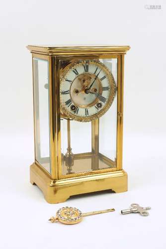 An early 20th century brass framed four-glass clock, the white enamel dial with black roman