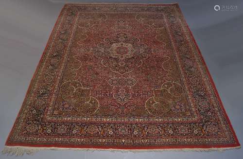 A Kashan carpet, with indigo pole medallion in deep red field with over all foliate design and