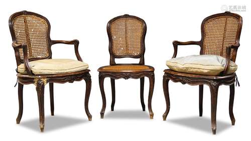 A pair of Louis XV beech and caned fauteuils, mid 18th Century, the cartouche shaped back centred by