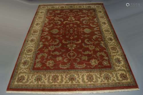 An Indian carpet of Ziegler design, with entwined foliate stems in brick red field, with ivory