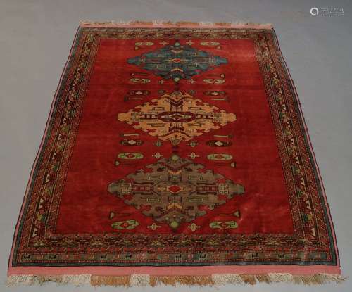 A Kazak part silk rug, late 20th Century, with triple medallion in deep red field with multiple