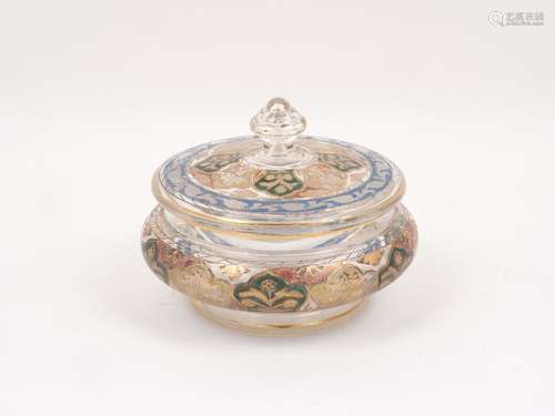 A glass lidded bowl in the Indian style, decorated with gilt floral motifs within coloured glass