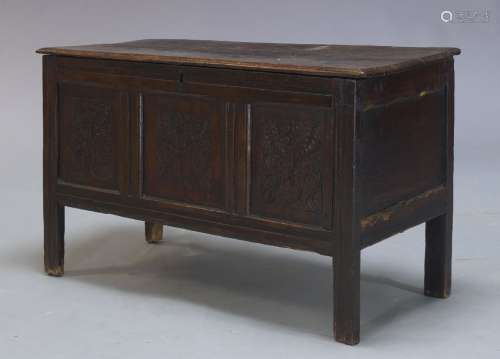 An oak coffer, 17th Century, the two plank lid above triple panel frieze, with floral carved motifs,