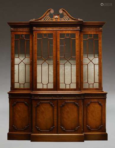 A George II style breakfront bookcase by Wade, late 20th Century, with pierced swan neck pediment,