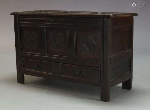 An oak mule chest, with triple panel lid, above conforming triple panel frieze with carved lozenge