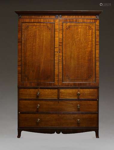 A Regency mahogany linen press, the moulded cornice with ebonised roundels above two ebony strung