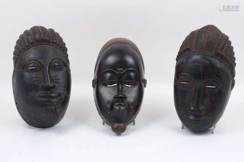 A group of three Baule masks, late 20th century, each of typical composition, largest 30cm long (3)