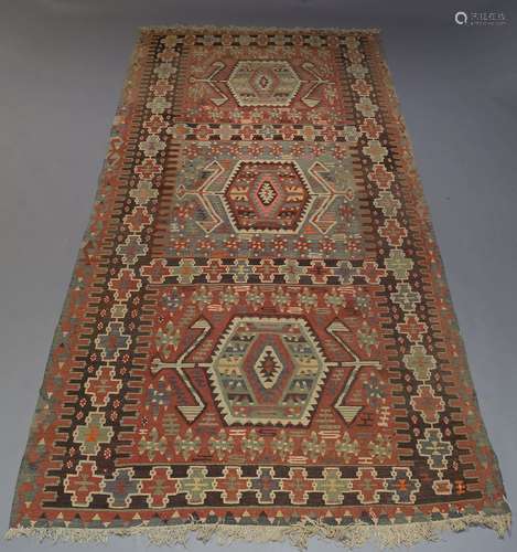 An Anatolian Kilim, with three hexagonal medallions and repeat geometric design border, 343cm x