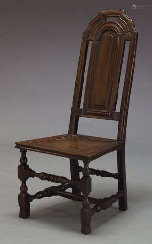 An oak side chair, 17th Century and later, the shaped, moulded and pierced backrest, above plank