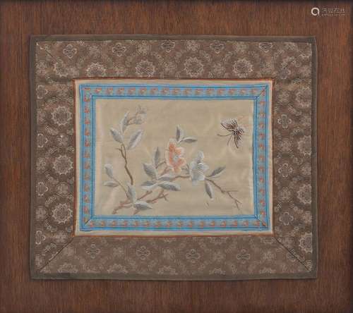 A matched pair of early 20th Century Chinese silk embroidered panels, each with central floral spray