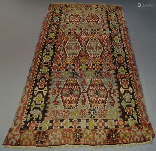 An Anatolian Kilim, the polychrome field with six hexagonal lozenge medallions and all over