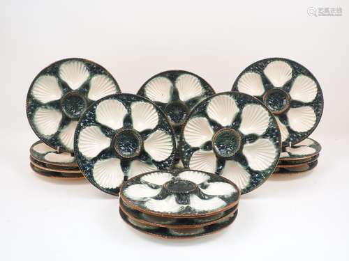 A set of fifteen Majolica oyster dishes, the circular bowls designed with six recessed shells, to