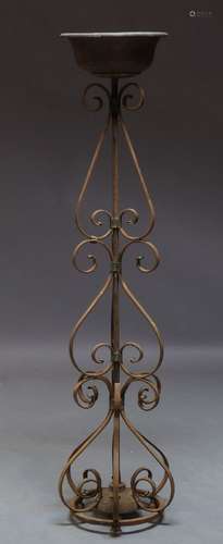 A wrought iron torchere stand, late 19th, early 20th Century, with copper bowl on open wrought