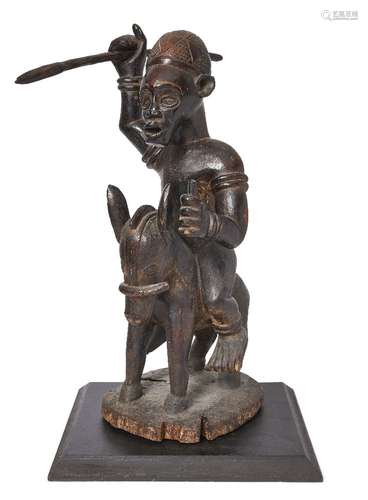 A Senufo carved wood equestrian figure, the figure modelled holding a spear with bangles on his arm,