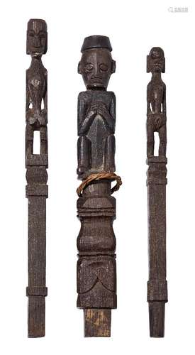 A tribal hardwood carved finial of a crouching man, possibly Luba, modelled with his hands in