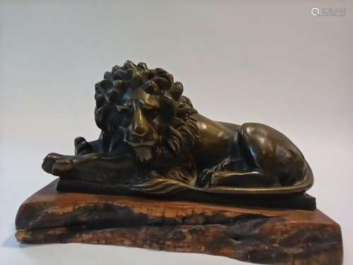 Lying lion in bronze on a wooden base. \n \nHt.: 8 c…