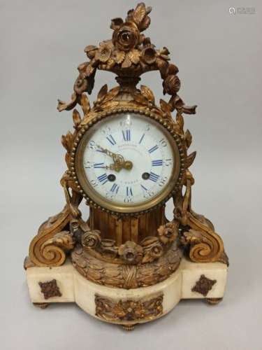 A chased and gilded bronze clock in the shape of a…