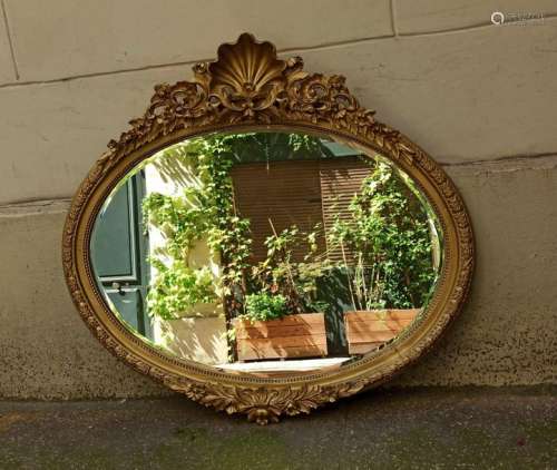 Oval wooden and stucco carved and gilded mirror wi…