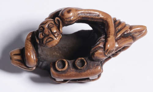 A WALNUT PENDANT CARVED WITH FIGURE