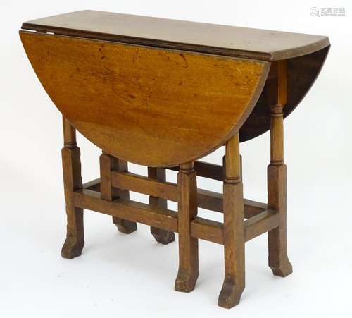 A late 19thC oak gateleg table, having drop flaps opening to form an oval table top and standing