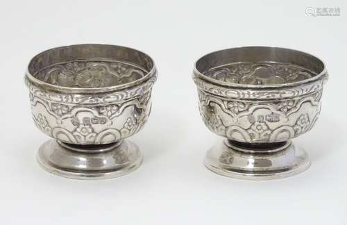 A pair of silver pedestal salts with embossed decoration. Hallmarked Sheffield 1902 maker Martin,