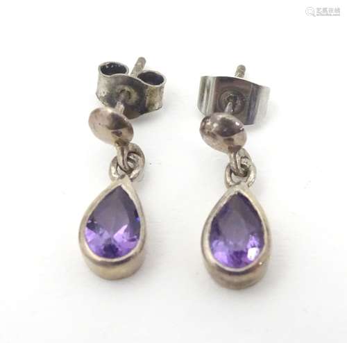 A pair of silver earrings set with amethyst drops 3/4