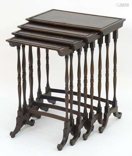 A 19thC mahogany nest of four tables with turned tapering legs and curved stretchers on shaped feet.