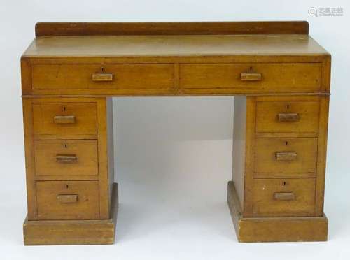 An early / mid 20thC Cotswold school double pedestal desk comprising two long drawers above two