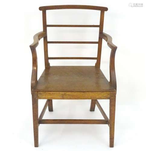 An oak Regency opem armchair of large proportions, having a curved top rail and back rails with