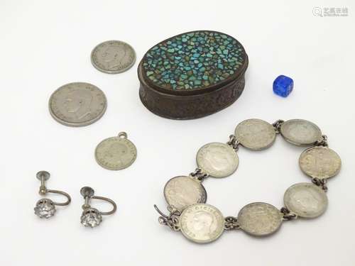 A pill box containing a bracelet made from three pence coins, a pair of earrings marked