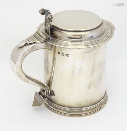 A Victorian silver lidded tankard, with flat lid, scrolling handle with heart formed terminal.