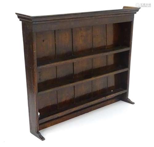 An 18thC elm wall hanging rack with a moulded cornice above three shelves. 49