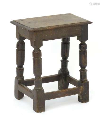 A late 17thC oak peg jointed stool with a rectangular moulded top and raised on turned legs with a